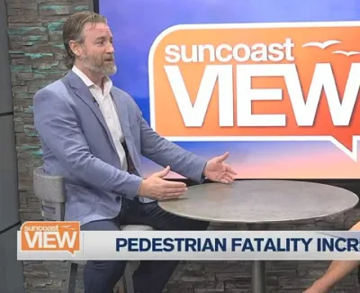 Two news anchors discussing pedestrian fatality increase on Suncoast View TV show set.