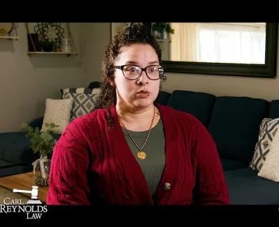 Woman with glasses and red sweater sitting on a couch in a living room for a law firm advertisement