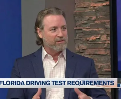 Man in suit discussing Florida driving test requirements on a local news interview set.