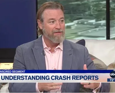 Man in a gray blazer discussing understanding crash reports on a news segment with ABC 7 logo.
