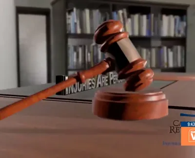 Wooden judge gavel resting on sound block in a law office with bookshelves in the background.