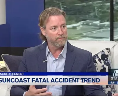 Man in suit discussing Suncoast fatal accident trend on a news segment with living room background.