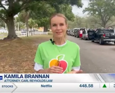 Kamila Brannan, attorney, speaking outdoors near parked cars and trees during news segment.