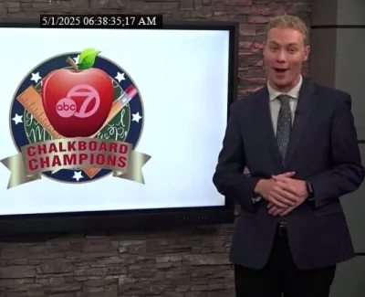 Two news anchors standing beside a screen showing the ABC 7 Chalkboard Champions logo with an apple and school supplies.