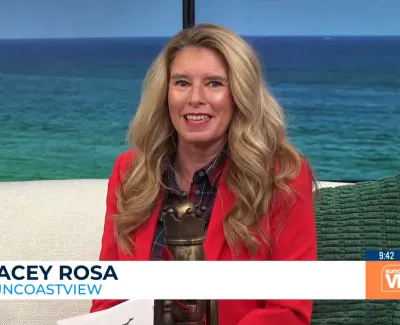 Female TV host Tracey Rosa on Suncoast View set with ocean backdrop and green cushion on sofa