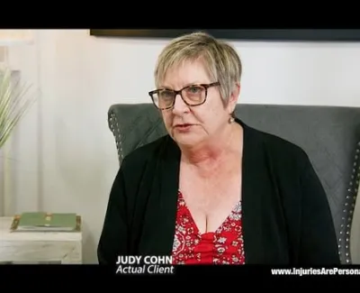 Woman with glasses sharing testimony in a home setting for a legal services testimonial video.