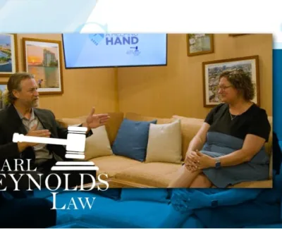 Two people engaged in a discussion in a cozy office setting with Carl Reynolds Law branding visible