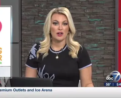 News anchor presenting an Ending Hunger food giveaway event on ABC 7 with colorful studio background