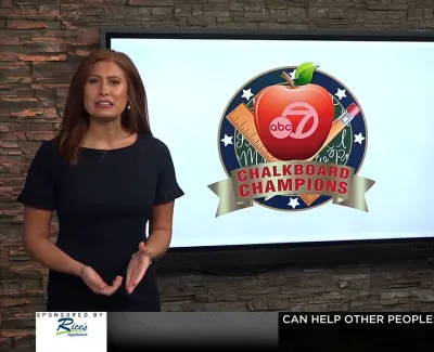 Two news anchors presenting ABC 7 Chalkboard Champions segment on television studio set