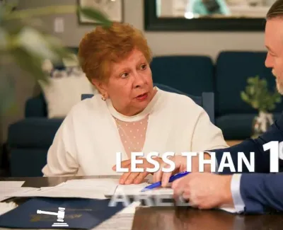 Two people in discussion at a table with papers, highlighting the text Less than 1% in the foreground.