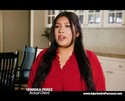 Woman in red blouse speaking in a bright, modern kitchen setting during legal client testimonial.