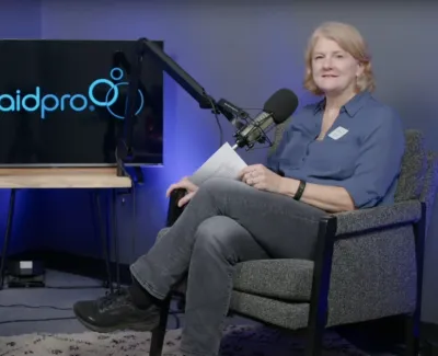 Two women seated in a podcast studio with MaidPro logo on a screen behind them.