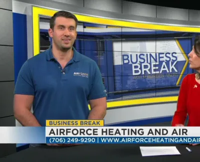 Two hosts discuss Airforce Heating and Air on the Business Break TV segment with contact info displayed