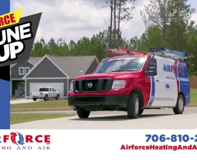 Red and blue Airforce Heating and Air service van parked in a residential driveway during daytime.