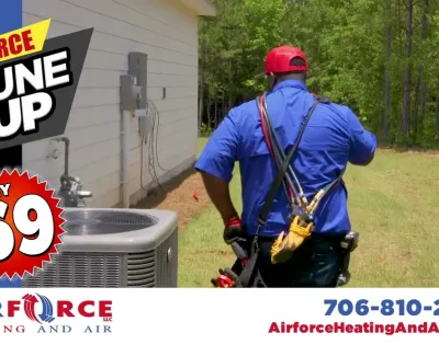 Technician in blue uniform walking outside a house near an air conditioning unit for Airforce Heating and Air service.