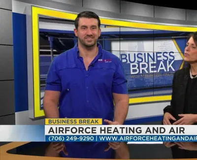 Man in blue Airforce Heating and Air uniform and woman in black jacket on Business Break TV segment