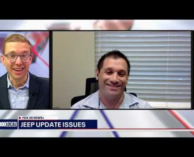 Two men discussing Jeep update issues during a Fox 35 News video call interview.