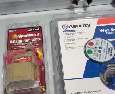 Aquaguard magnetic float switch and Asurity wet switch flood sensor packaging on a metal surface near wiring.