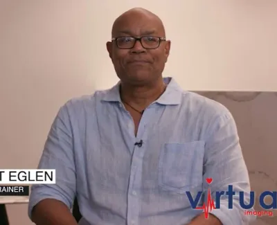 Personal trainer Ernest Eglen sitting in a light blue shirt with Virtual Imaging Inc logo on screen.