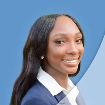 Professional young woman in blazer smiling confidently against a blue background with curved design.