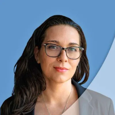 Portrait of confident woman with glasses and dark hair against a blue background with geometric overlay