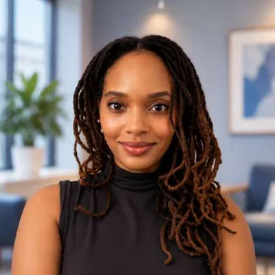 Confident young woman with long dreadlocks and black sleeveless top in modern office setting