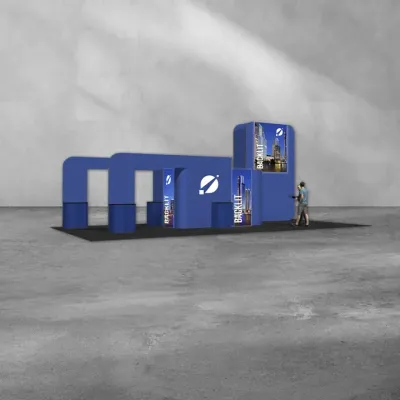 Blue modular trade show booth with Backlit displays and a person walking nearby on concrete floor.