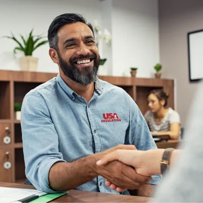 a man smiling and shaking someone's hand