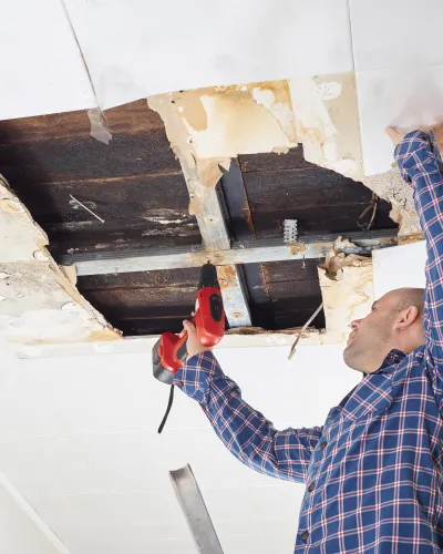 An employee repairing a damaged roof