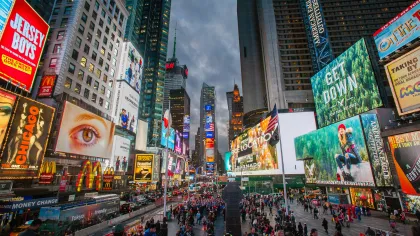 a busy city street with Times Square in the background