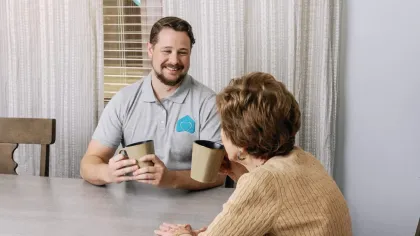 a man and a woman sitting at a table looking at a cell phone