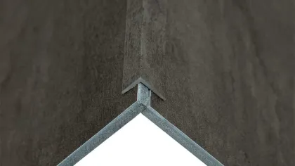 Close-up of interlocking metal and dark textured panels forming a right angle corner joint.
