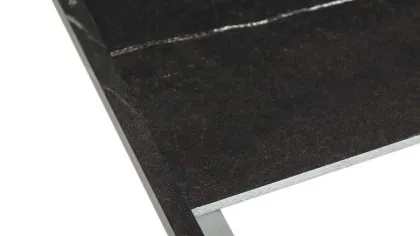 Black marble tile with polished metal trim on corner edge isolated on white background