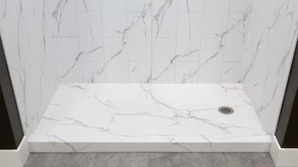 Modern walk-in shower with white marble tiles and gray flooring featuring a metal drain on the right side.