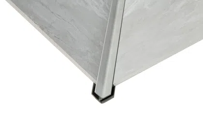 Close-up of a corner wall with a metal corner guard protecting the edge of gray marble or stone surface.