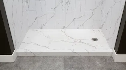 Modern walk-in shower with white marble tiles and stone textured gray floor outside the shower.