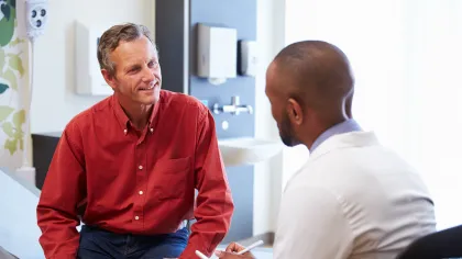 two men sitting and talking to one another