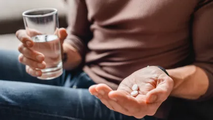 a person holding a glass of liquid