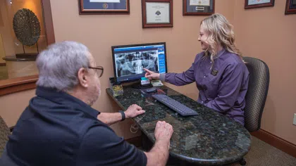 Dental professional reviews a patient's dental X-ray on a computer screen in an office setting