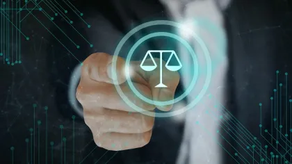 Hand pointing to digital scales of justice icon representing law and legal technology concept