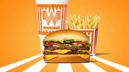 Whataburger double cheeseburger with lettuce, tomato, fries, and a drink on an orange background with white stripes.