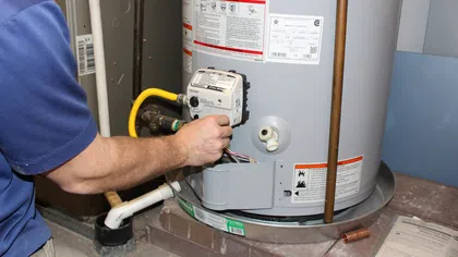 A technician performing a water heater service.