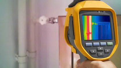 Person using a thermal imaging camera to inspect plumbing for leaks and temperature variations.