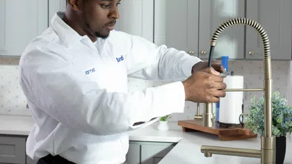 A Bardi plumbing technician repairing a kitchen sink
