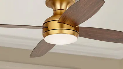 Ceiling fan with a gold finish and wooden blades, featuring integrated lighting for stylish home cooling.