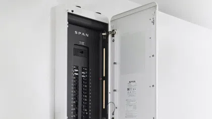 Open SPAN electrical panel with switches and circuit breakers mounted on a white wall