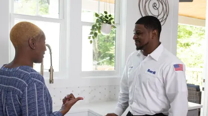 a man talking to a man in a white shirt