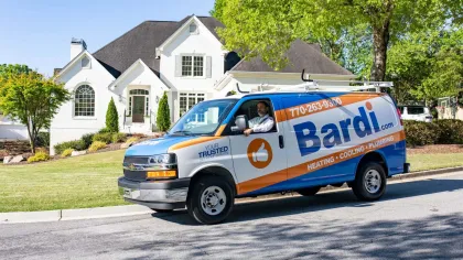 Bardi service van parked outside a modern house with lush greenery and blue sky.