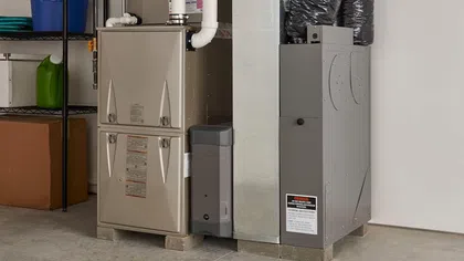 Energy-efficient heating system with a furnace and air conditioning unit installed in a garage setting.