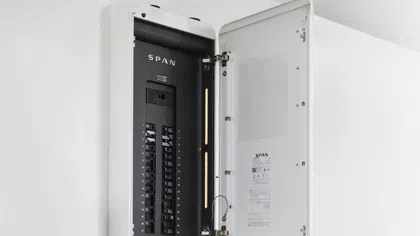 Open SPAN electrical panel breaker box mounted on a white wall with visible circuit breakers and labels